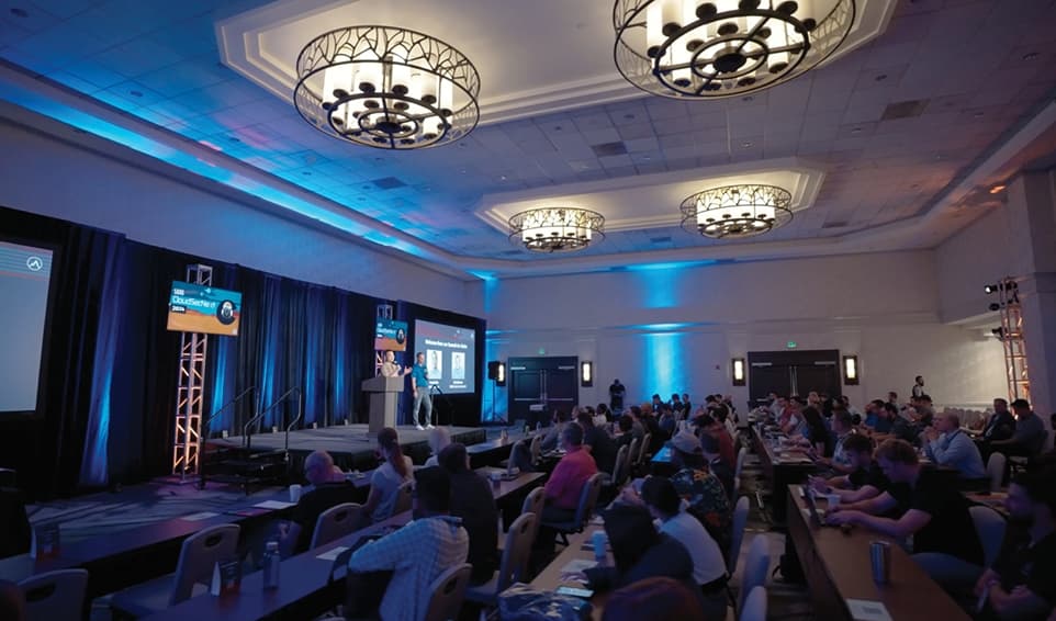 Summit Room with People Talking on Stage