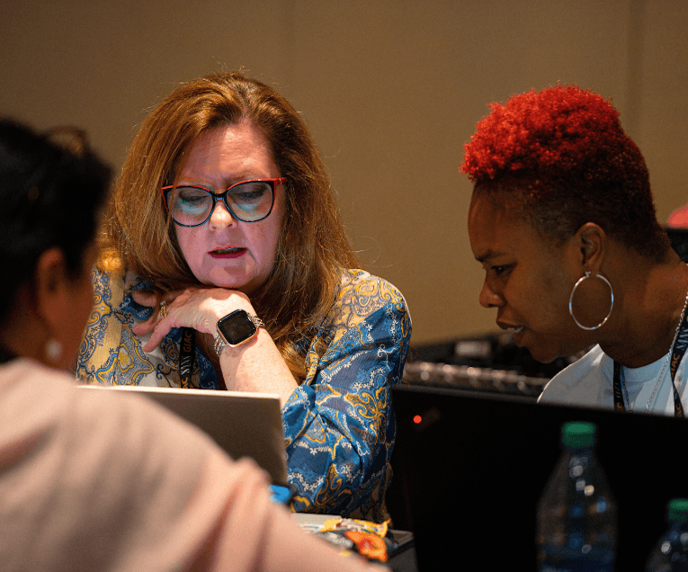 Two Woman Looking at Laptops