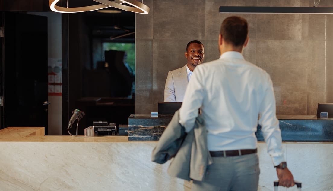 Hotel Clerk Smiling at Guest