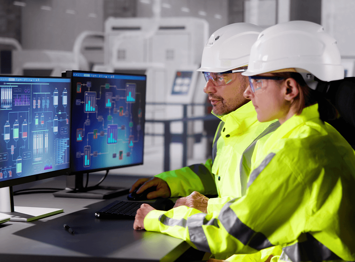 People Wearing Hardhats At Computers