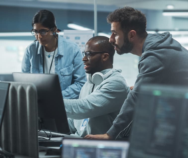 Three People Looking at a Computer