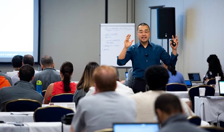 Frank Kim Wearing a Blue Shirt and Teaching In Classroom