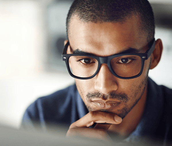 Pensive man staring at laptop