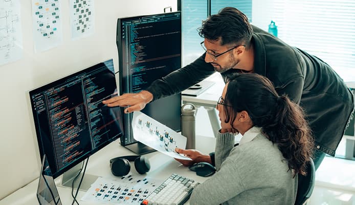 Man Pointing at Code While Woman Looks