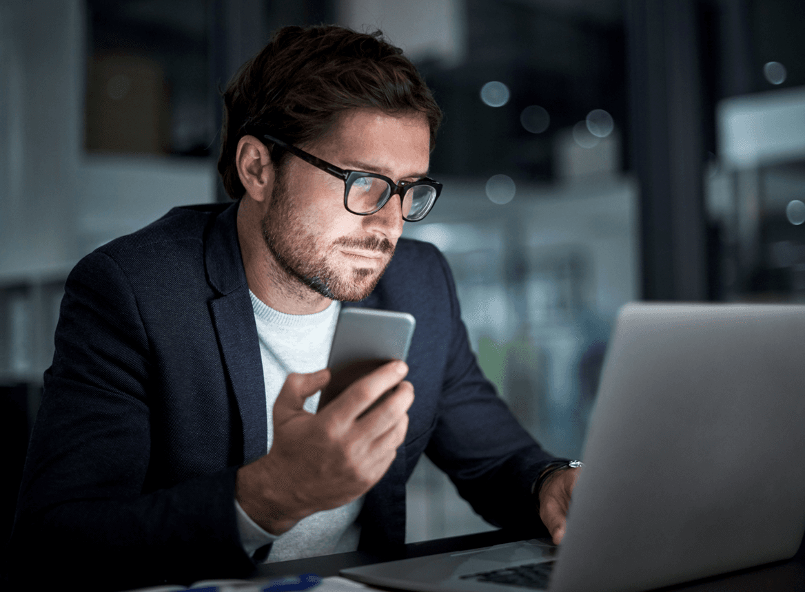 Man Using Laptop and Phone: Global