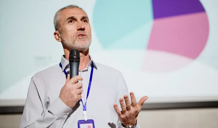 Close Up of Man Speaking into Microphone on a Stage