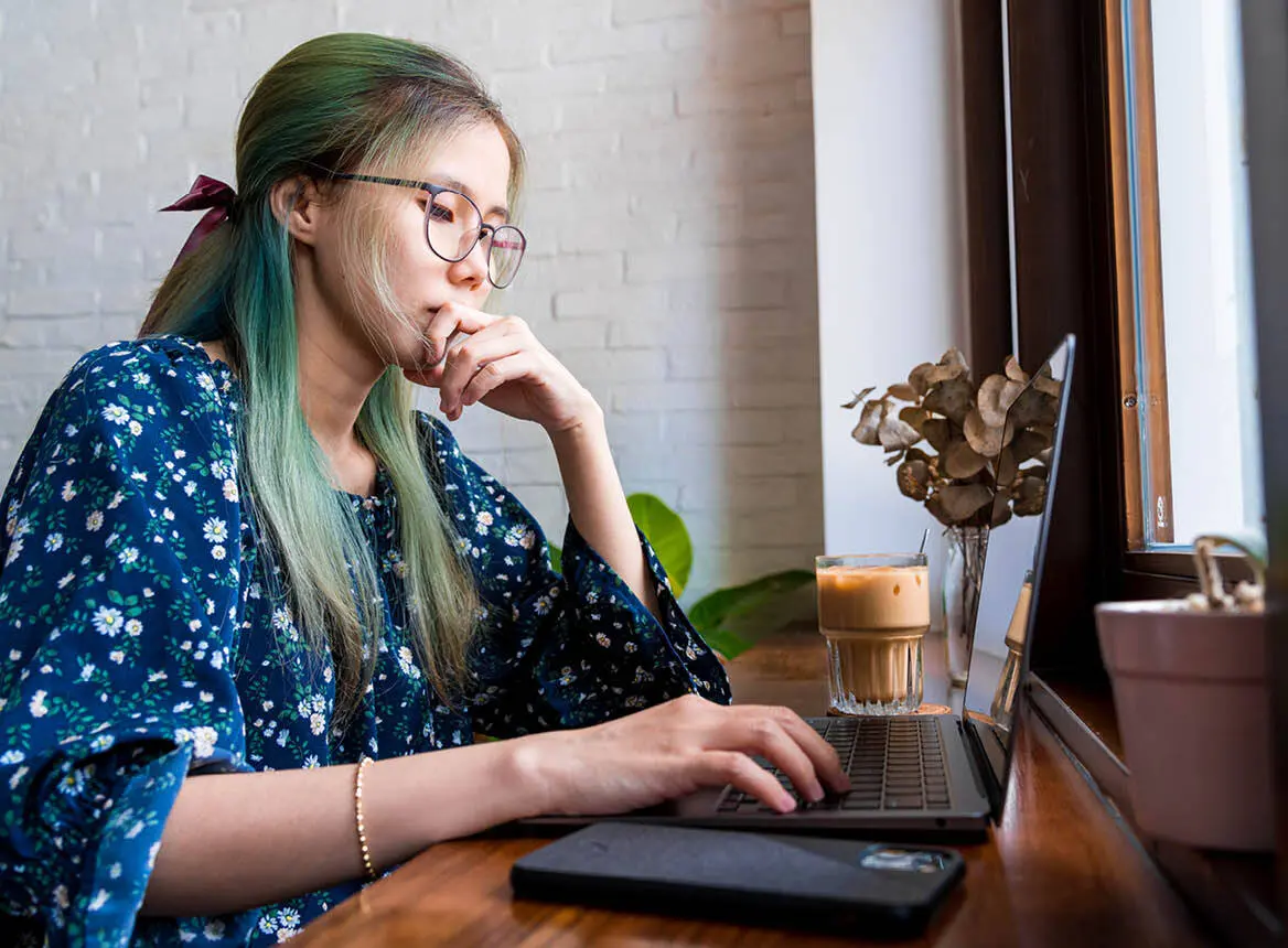 Woman Sitting at Laptop With Coffee: